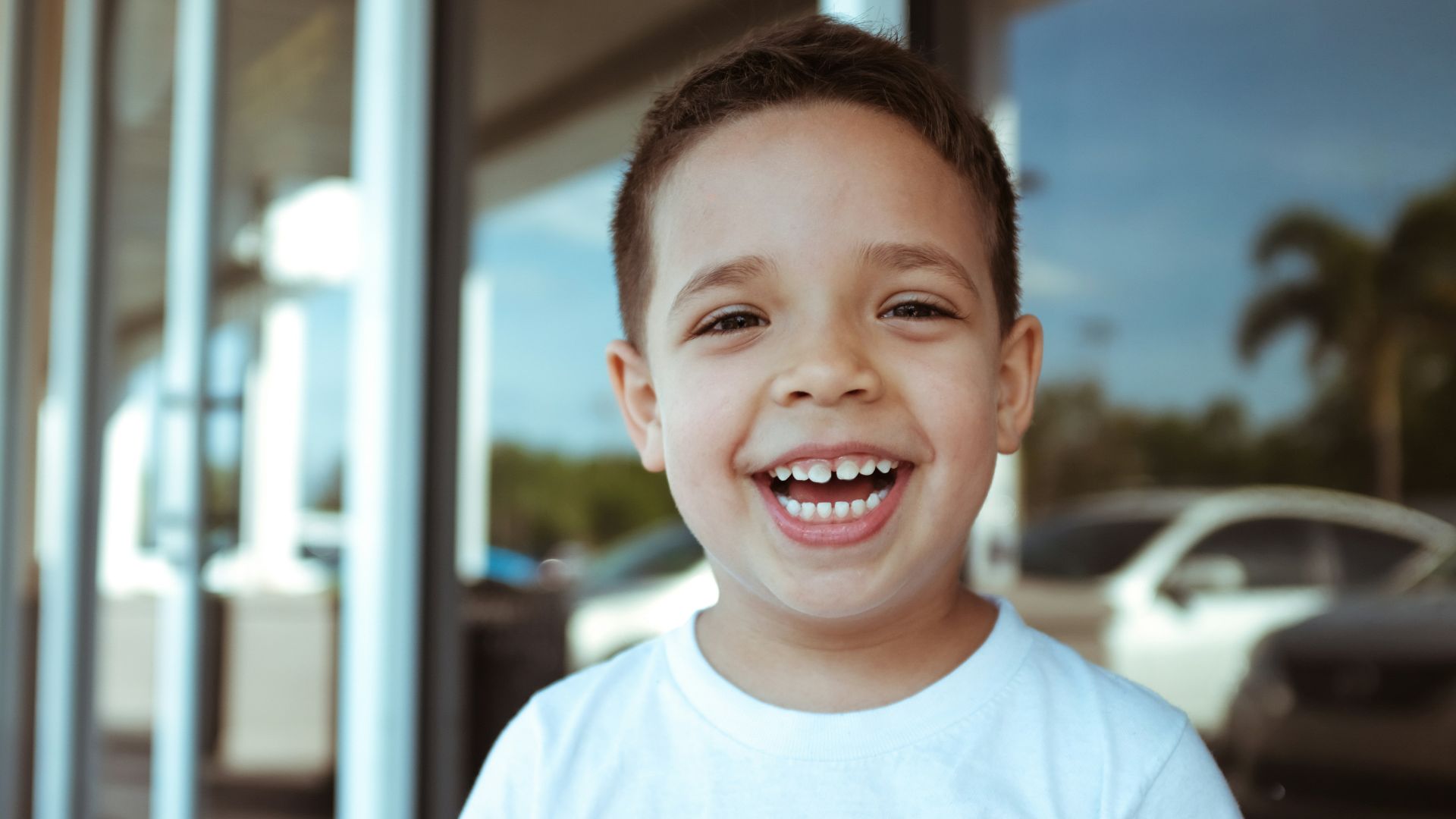 smiling boy wearing white crew-neck t-shirt during daytime