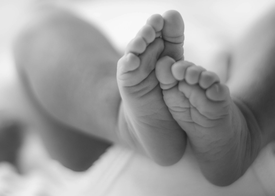 grayscale photo of babys feet