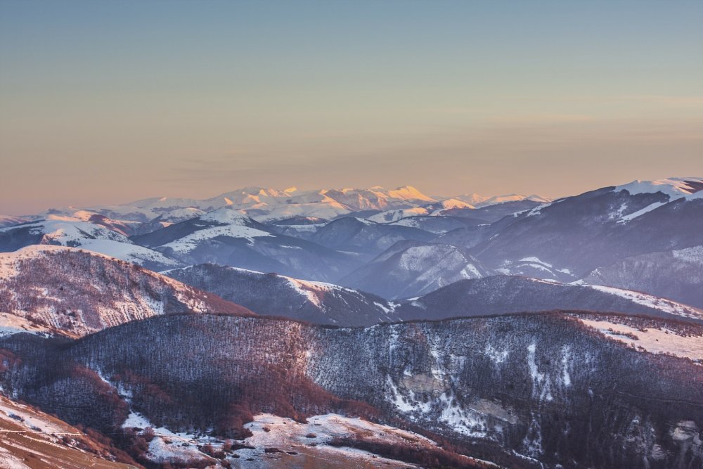 Sibillini Mountains in the snow at sunset, aerial view from Mount Cucco
