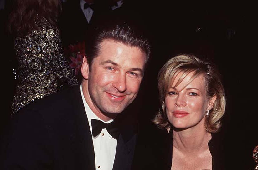 Married American actors Alec Baldwin and Kim Basinger sit at a table
