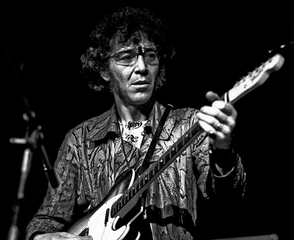 Alexis Korner playing guitar on stage