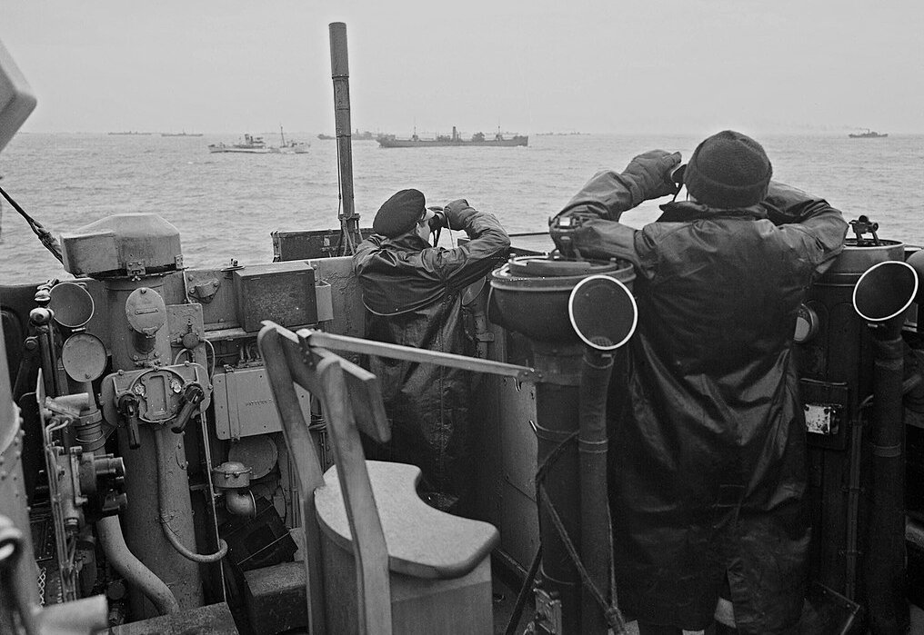 Officers on the bridge of a destroyer, escorting a large convoy