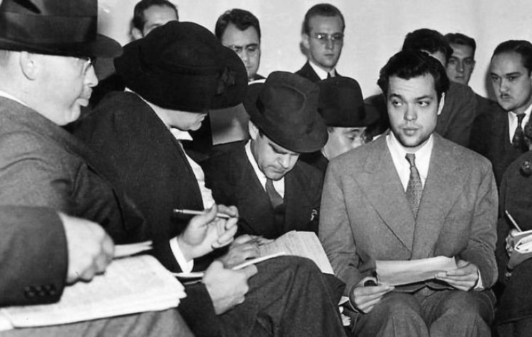 Photo of Orson Welles (center) meeting with reporters after the War of he Worlds radio broadcast