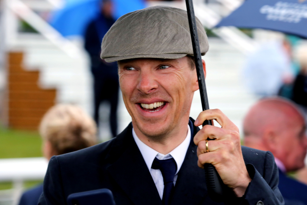 Benedict Cumberbatch in suit holding an umbrella