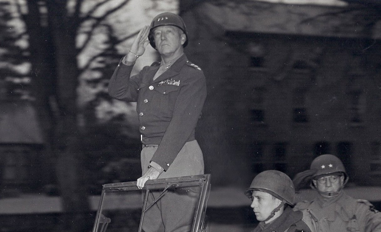 Major General Walter M. Robertson (back seat), commanding the 2nd Infantry Division, with Lieutenant General Patton pass in review of elements of Patton's Third Army