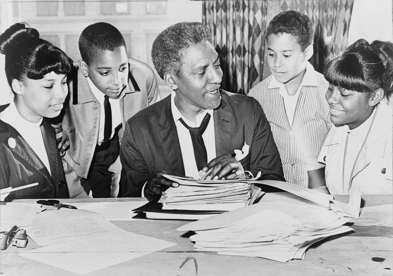 Bayard Rustin (center) speaking with people