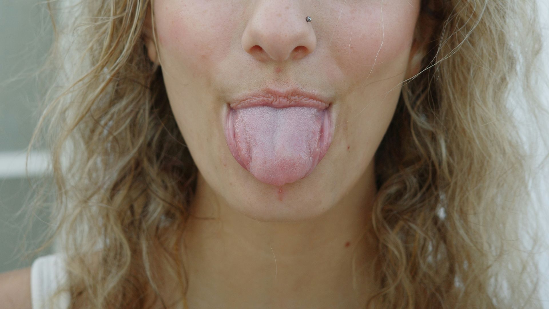 A woman sticking her tongue out with her eyes closed