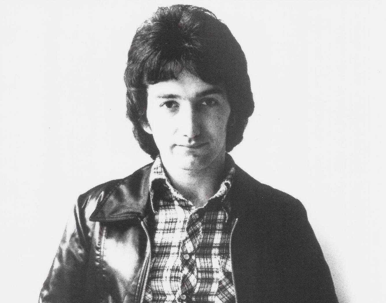 John Deacon of Queen in a Grayscale promotional photo