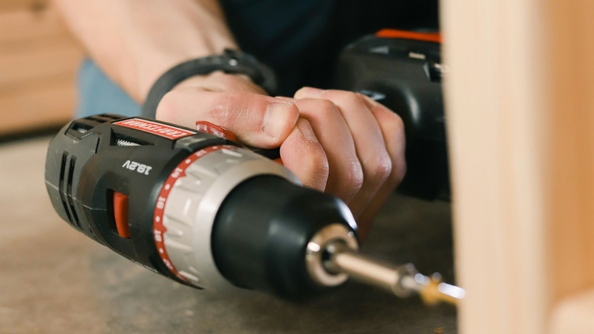 person holding black and red cordless hand drill