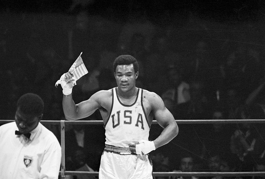 George Foreman of Houston, TX, waves a small American flag after he won the Olympics heavyweight boxing gold medal