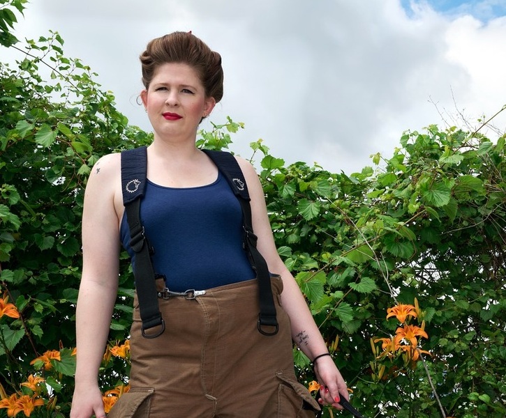A woman standing in front of a bush