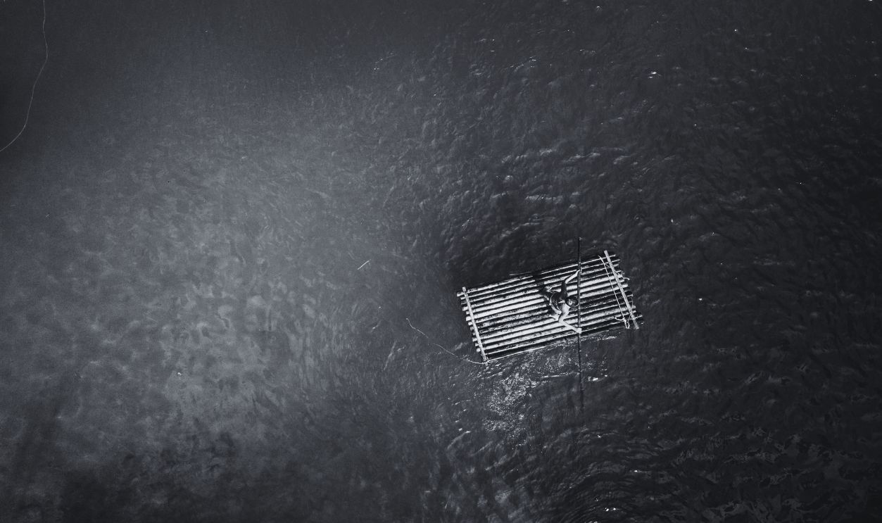 Drone shot aerial view of young woman bamboo rafting at tropical waterfall - stock photo High angle view from drone shot aerial view of young woman bamboo rafting on a beautiful waterfall on Siquijor Island in the Philippines. People travel nature outdoor activities concept. One person only enjoying outdoors and tranquillity in a peaceful environment, solo traveler concept