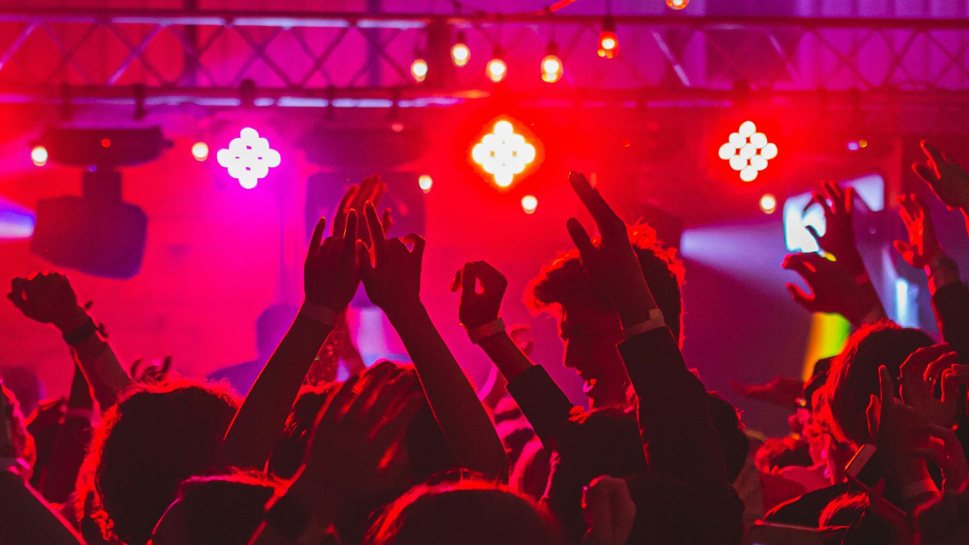 people standing on stage with lights turned on during nighttime