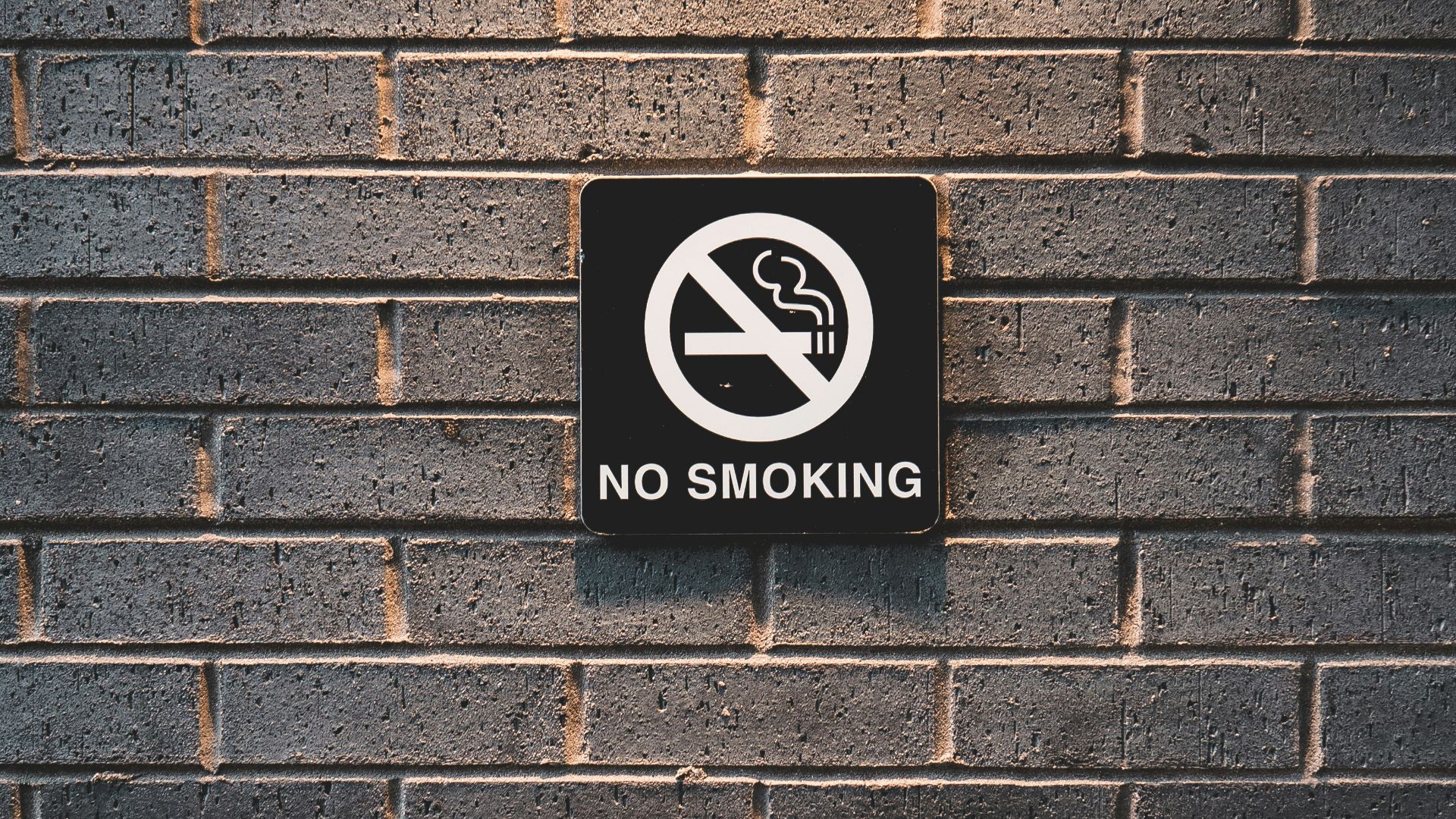 no smoking sign on brick wall