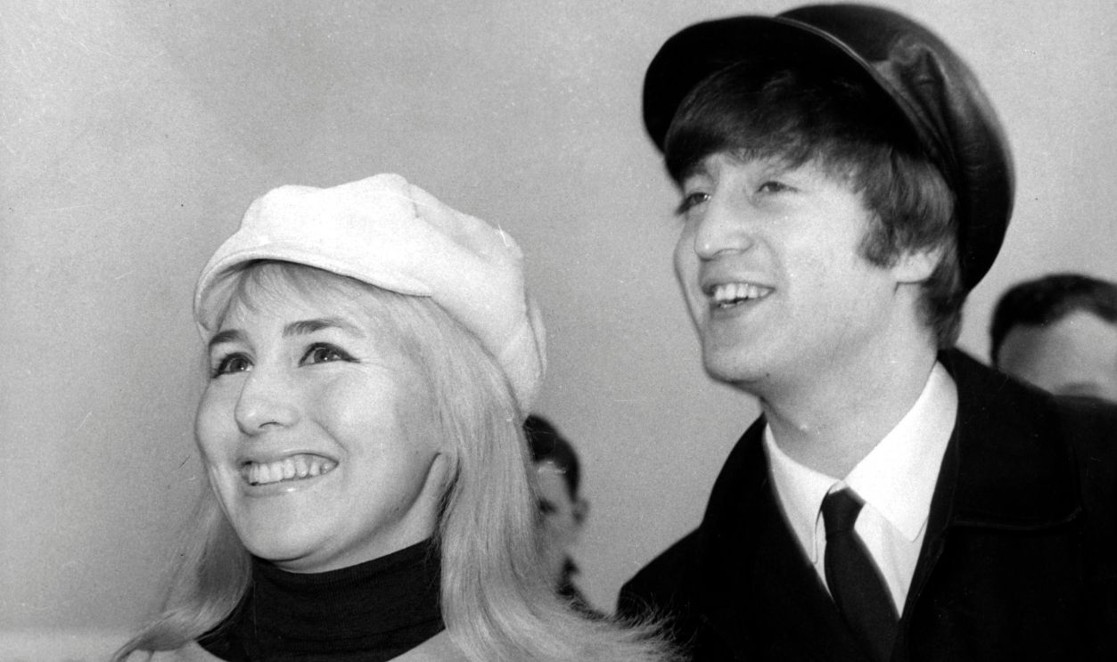 Gettyimages - 91139179, Photo of John LENNON and Cynthia LENNON UNITED KINGDOM - FEBRUARY 07: Photo of John LENNON and Cynthia LENNON; while in The Beatles, posed with his wife Cynthia (wearing plastic mac) at Heathrow Airport