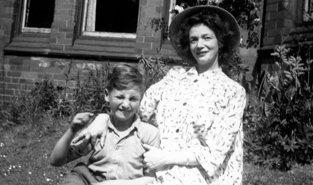 John Lennon and Julia Lennon CHESHIRE, ENGLAND - 1949: Nine year old John Lennon (1940-1980) poses for a portrait with his mother Julia (1914-1958) in the front garden of