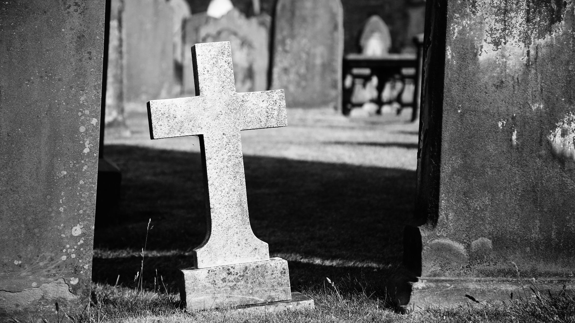 grayscale photo of gray graveyard cross