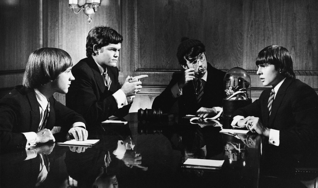 Gettyimages - 56704493, Monkees On Wall Street Musician/actors the Monkees, all dressed in suits, sit around a board room table equipped with a stook ticker in a scene from the television show 'The Monkees,' early 1970s. From left, Peter Tork, Mickey Dolenz, Michael Nesmith, and Davy Jones.