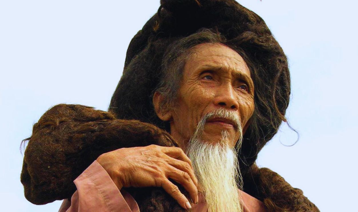 Tran Van Hay from the Chau Thanh district in southern Kien Giang province, poses while showing his over 6.2-meter long hair, 19 June 2004, in the southern city of Can Tho. Hay, who has not cut his hair for 31 years, is seeking a place in the world's Guinness Book of Records, claiming to have a mane measuring 20 feet, four inches. Hay said the last time he washed his hair was six years ago. AFP PHOTO/TRUONG CONG KHA