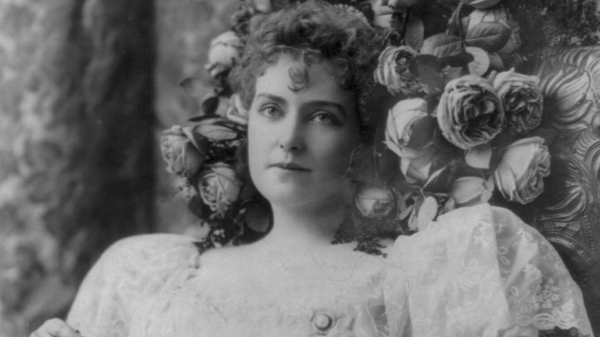 File:Lillian Russell, 1861-1922, half length portrait, seated in chair, flowers around head, holding fan, facing slightly left LCCN2005692229.jpg