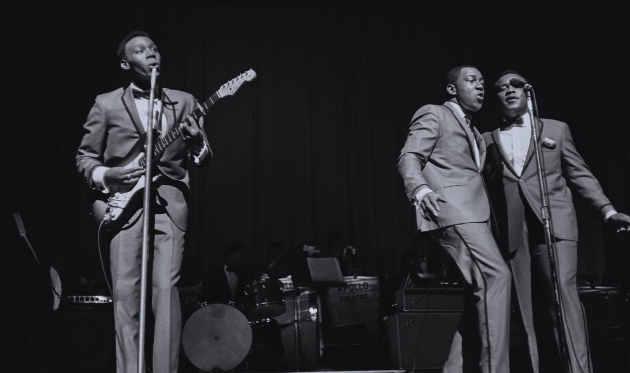 Gettyimages - 1319215599, The Impressions Play The Apollo American soul group The Impressions (American singer-songwriter and musician Curtis Mayfield (1942-1999), American singer Fred Cash, and American singer Sam Gooden) perform live at the Apollo Theater in the Harlem neighbourhood of Manhattan, New York City, New York, circa 1965. 