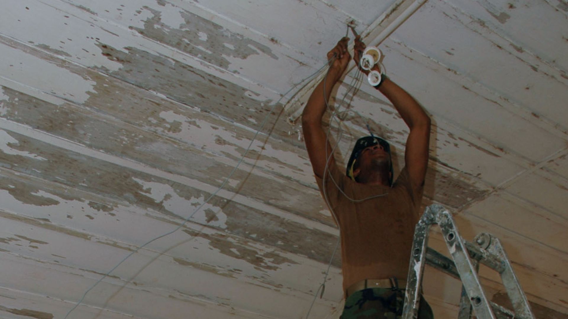 File:US Navy 090302-N-1655H-394 Utilitiesman 2nd Class Jospeh Tabor, left, and Construction Electrician 2nd Class Darius Michael, assigned to Naval Mobile Construction Battalion (NMCB) 11, install new wiring for lights.jpg