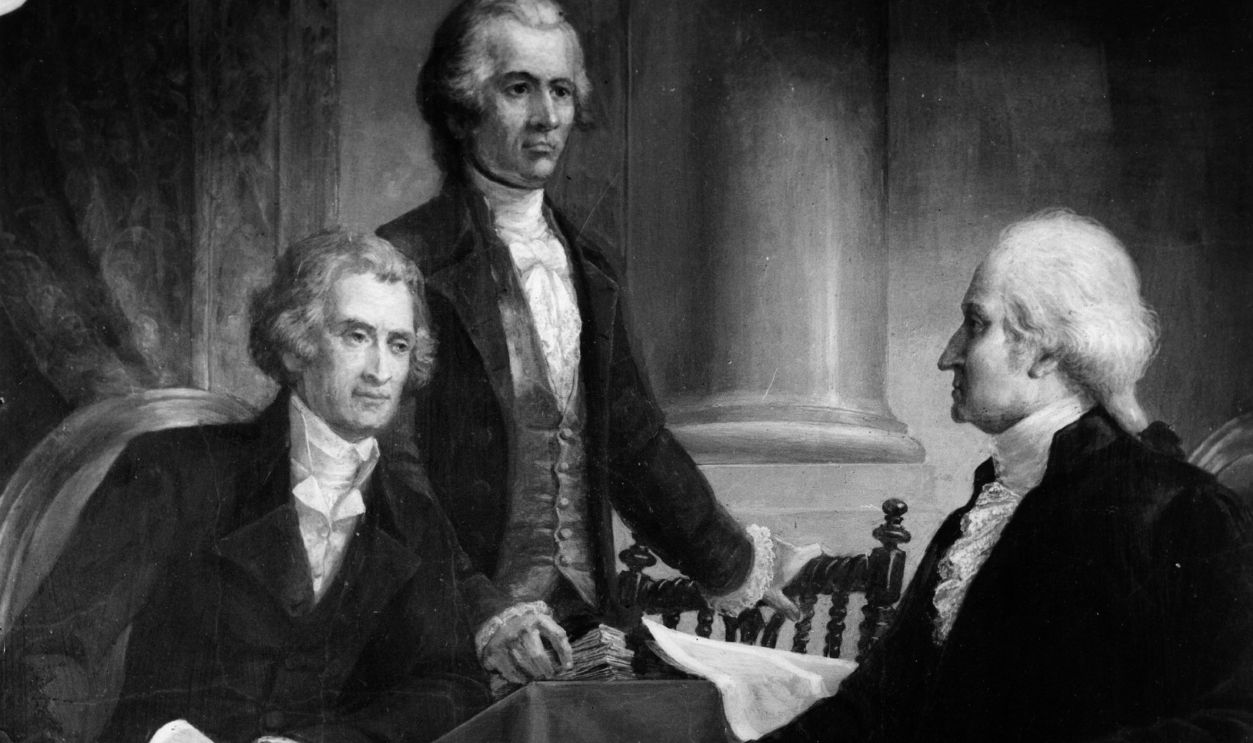 circa 1795: The 1st President of the United States, George Washington (1732 - 1799) in consultation with members of his first cabinet; Secretary of State Thomas Jefferson (seated), later the 3rd President and Secretary of the Treasury and co-author of the Federalist Papers, Alexander Hamilton.
