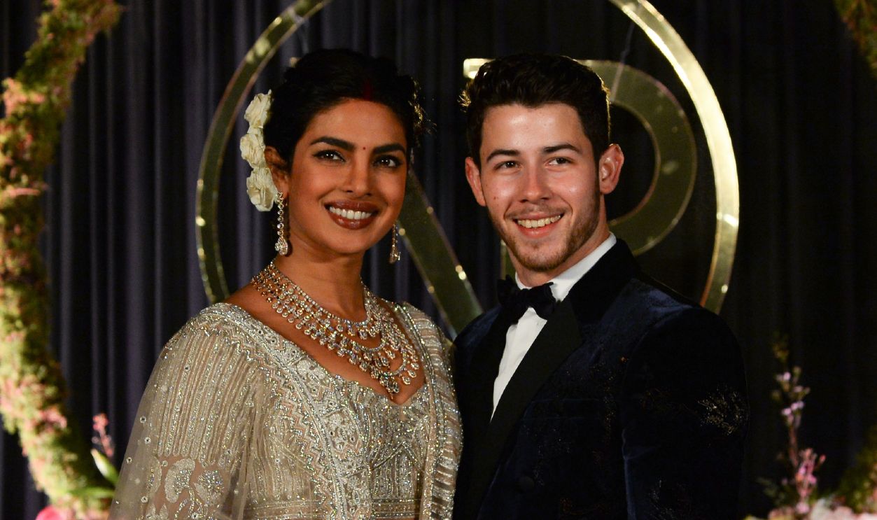 Indian Bollywood actress Priyanka Chopra (L) and US musician Nick Jonas, who were recently married, pose for a photograph during a reception in New Delhi on December 4, 2018. - Bollywood actress Priyanka Chopra and American singer Nick Jonas hosted an extravagant concert on December 2 for their star-studded wedding guests as the couple tied the knot at a lavish Indian palace