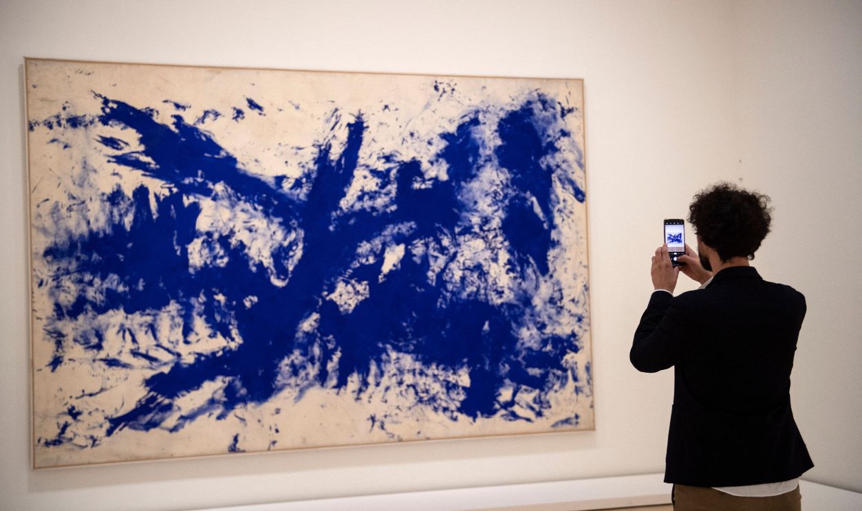 A visitor takes a picture of the artwork