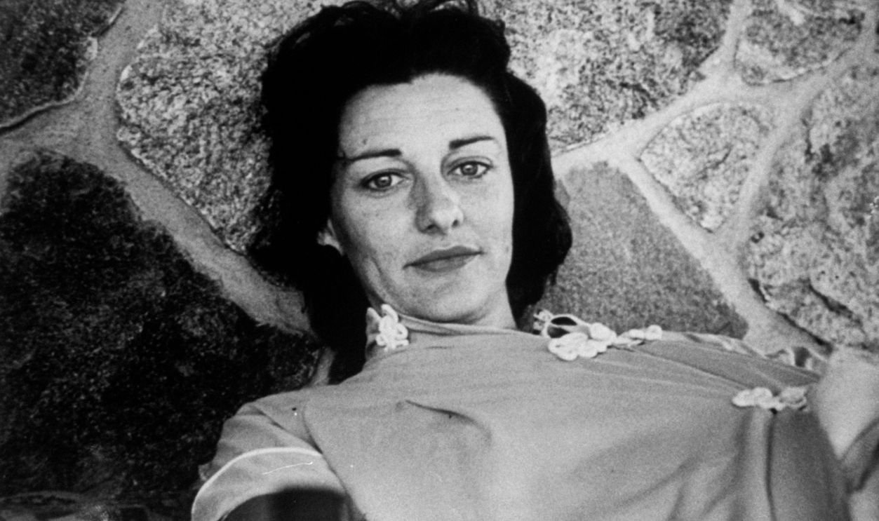 Poet Anne Sexton lying on stone patio.