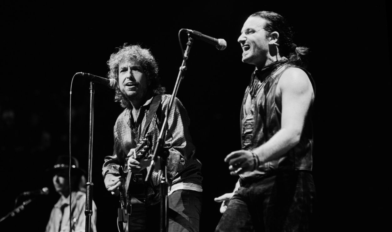 Grammy Award-winning singer Bono (right), of the rock group U2, performs songs from 