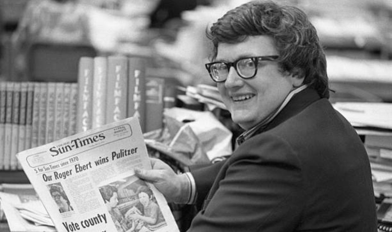 Roger Ebert, of the Chicago Sun-Times, whose film reviews are a feature of the Chicago paper and is syndicated to 100 other newspapers throughout the country holds a copy of the Sun-Times announcing his winning of the Pulitzer Prize for Criticism 5/5.