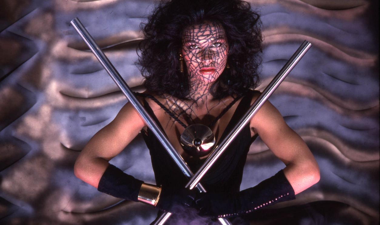 Portrait of the Canadian model and musician Vanity (born Denise Matthews, 1959 - 2016) is she poses in a black top, elbow gloves, and elaborate face-make-up, New York, 1982. The photo was taken during a session for the cover for funk and soul group Cameo's album, 'Alligator Woman.'