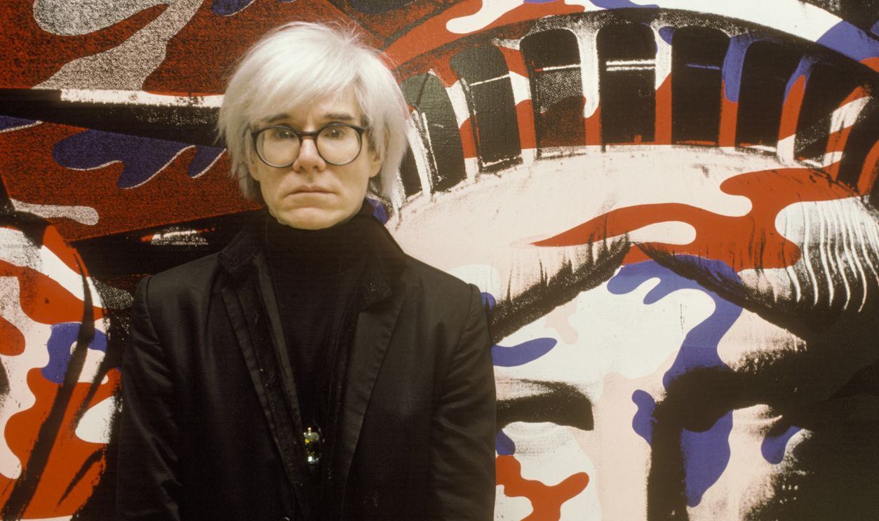 Andy Warhol standing in front of his painting of the Statue of Liberty in Paris, France on April 22nd, 1986. 