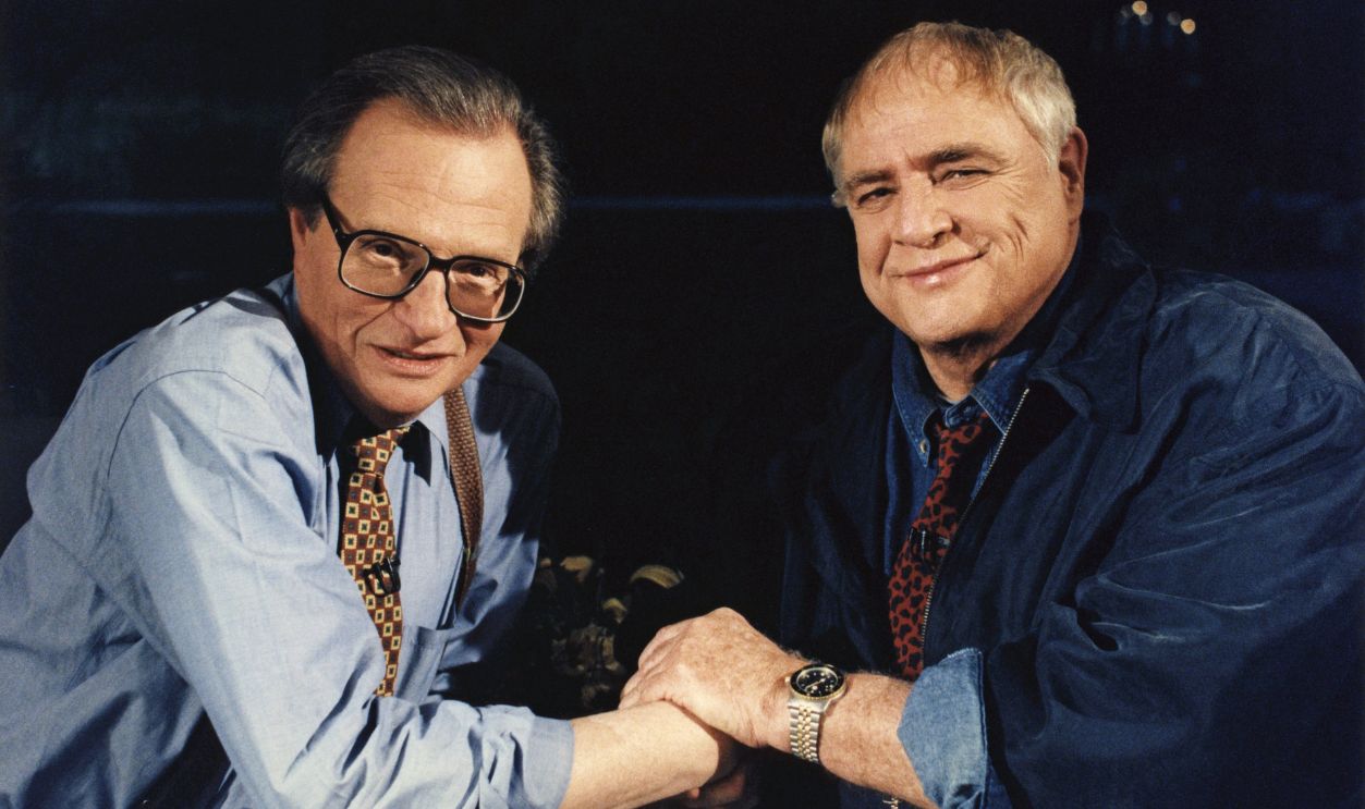 Actor Marlon Brando plants one on talk show host Larry King during the taping of 