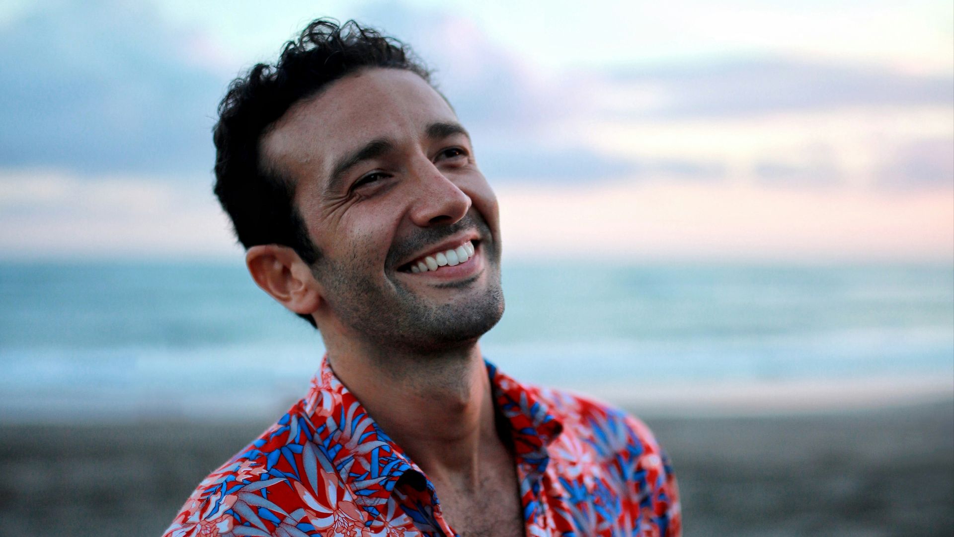 man in blue and orange button up shirt smiling