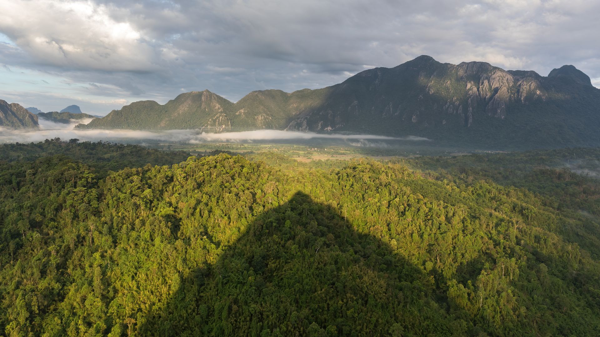 File:Conical shadow of Mount Nam Xay over green trees at golden hour, South-West view from the top, Vang Vieng, Laos.jpg