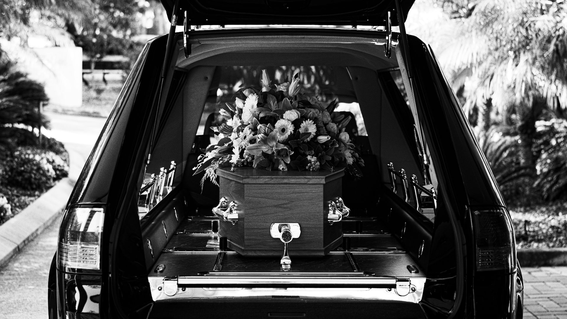 grayscale photo of car with flowers