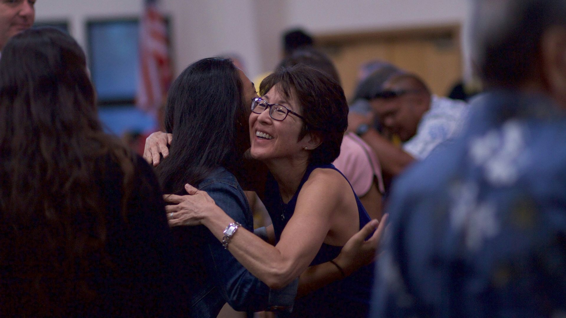 selective focus photography of two women hugging