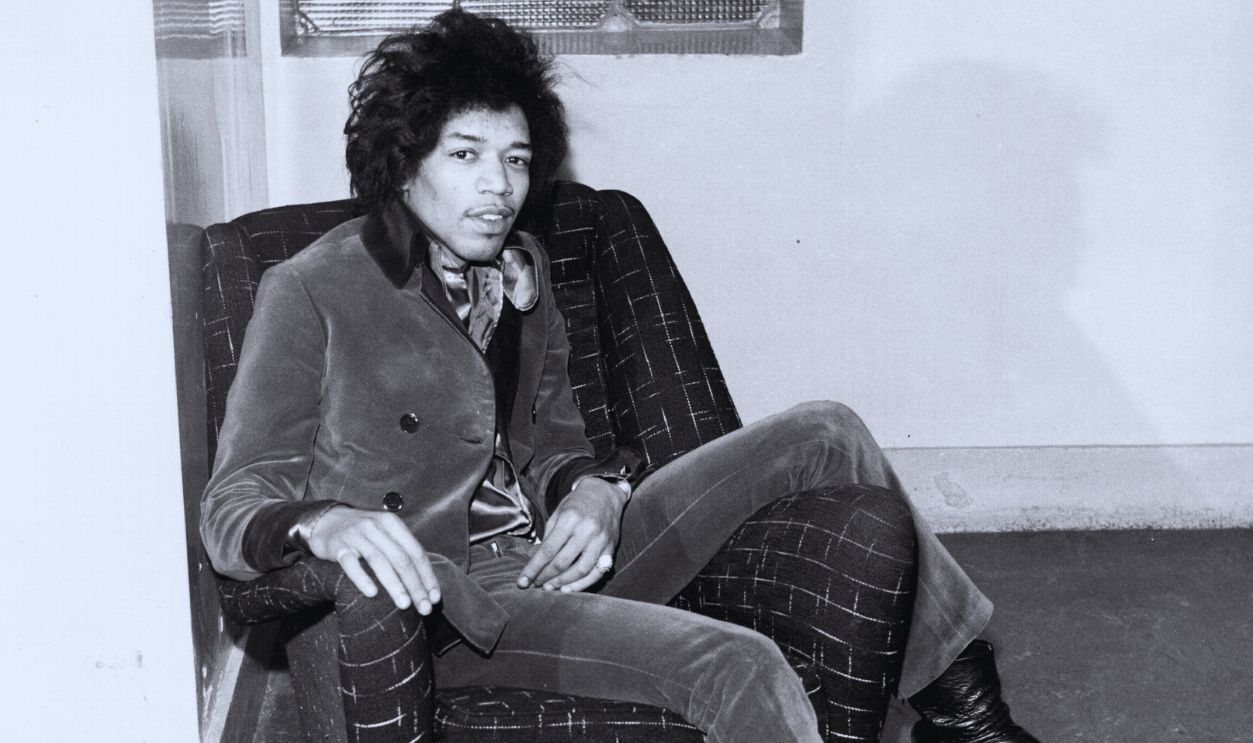 1966: Rock guitarist Jimi Hendrix poses for a portrait sitting in a chair in 1966 in London, England.