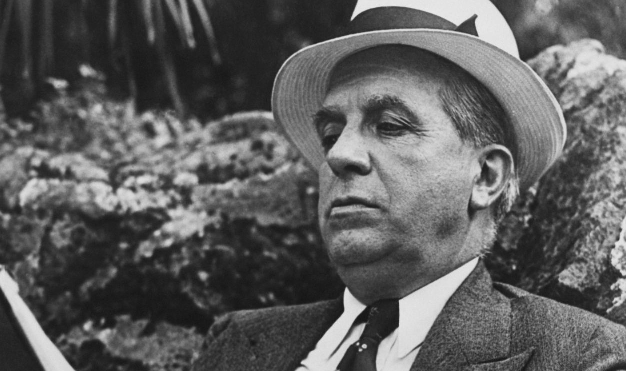 Italian-born American swindler Charles Ponzi (1882 - 1949), reading the manuscript of his autobiography a fortnight after his deportation from the United States, Rome, 31st July 1935. Ponzi had previously served 14 years in jail after the collapse of his fraudulent investment scheme, whereby early investors were paid from the investments of later investors. Such frauds have since been known as Ponzi schemes. (Photo by Keystone View Company/FPG/Archive Photos/Getty Images)