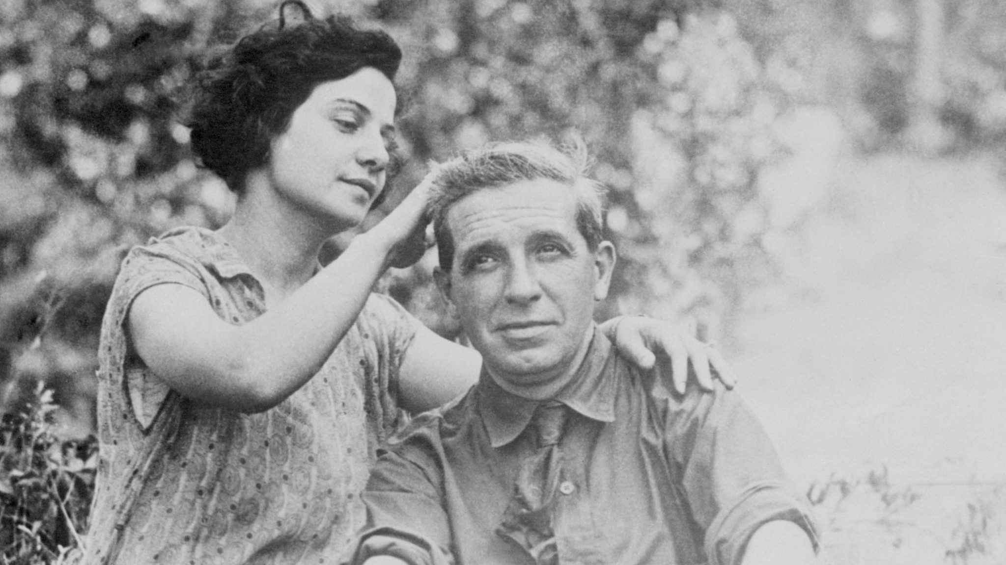 Rose Ponzi stroking her husband Charles Ponzi's hair while at their camp. Charles Ponzi was a scam artist who ran false investment firm.
