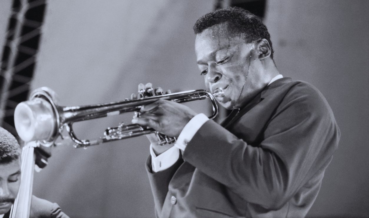   Gettyimages - 612576450, Miles Davis and Paul Chambers Performing at Randall's Island Jazz Festival Miles Davis sweating as he plays trumpet at the Randall's Island Jazz Festival in New York.