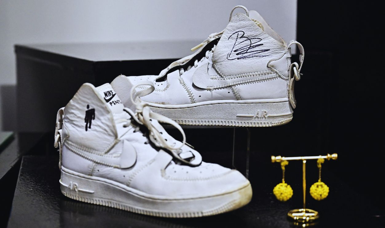   Gettyimages - 2199917598, US-AUCTION-CELEBRITY-FIRE Stage worn Nike Air Force 1 sneakers with signature (R) and drawing (L) by Billie Eilish are displayed at a preview for the 