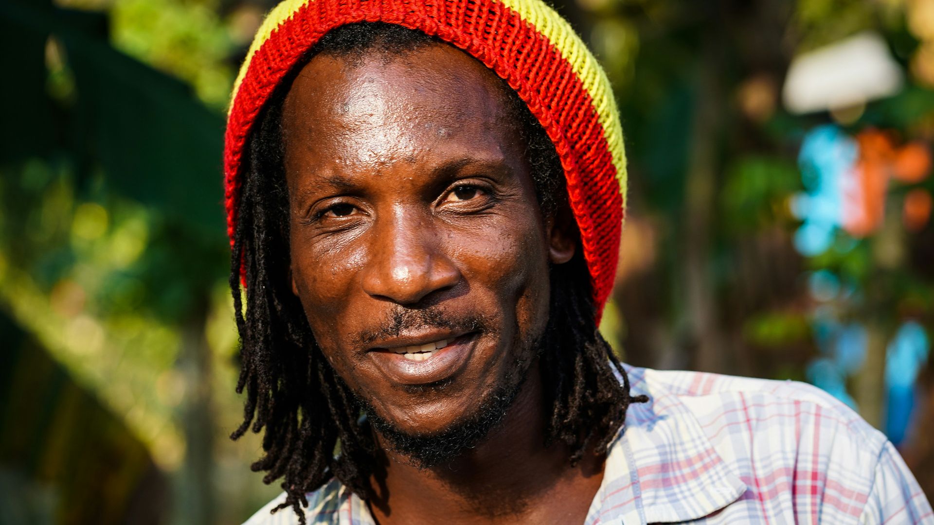 man in white blue and red plaid button up shirt wearing red knit cap