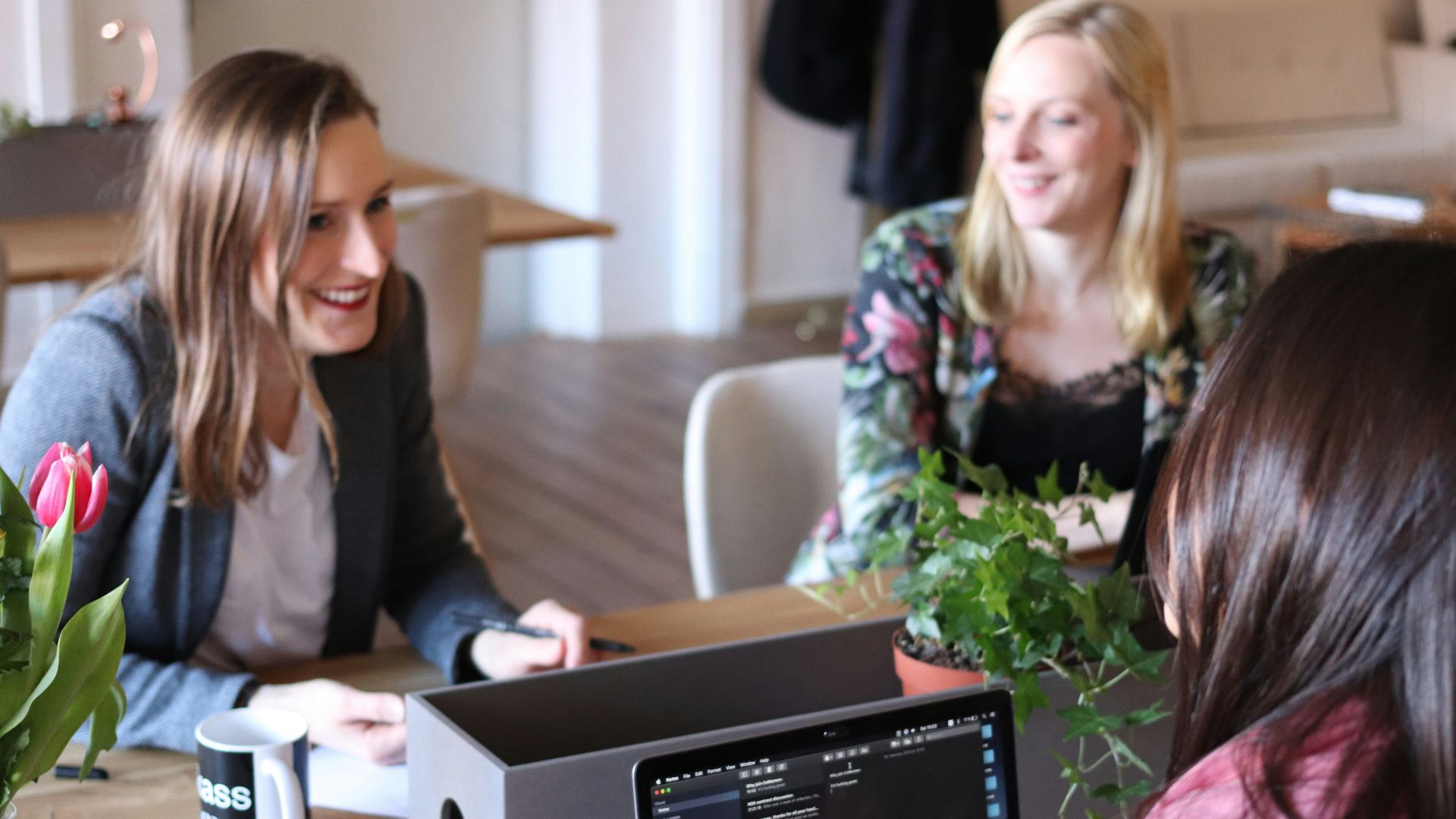 a group of women sitting around a wooden table