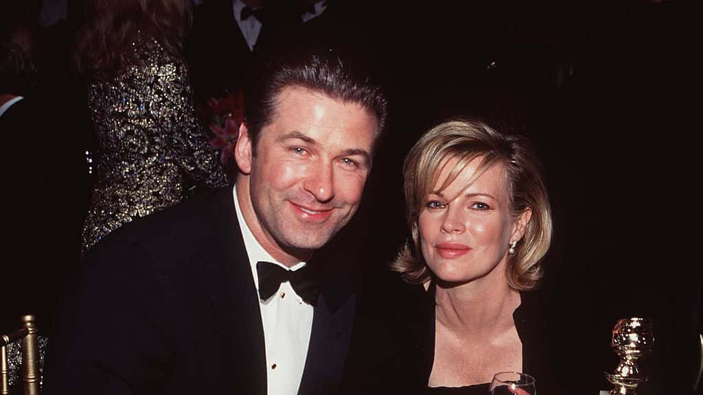 Married American actors Alec Baldwin and Kim Basinger sit at a table