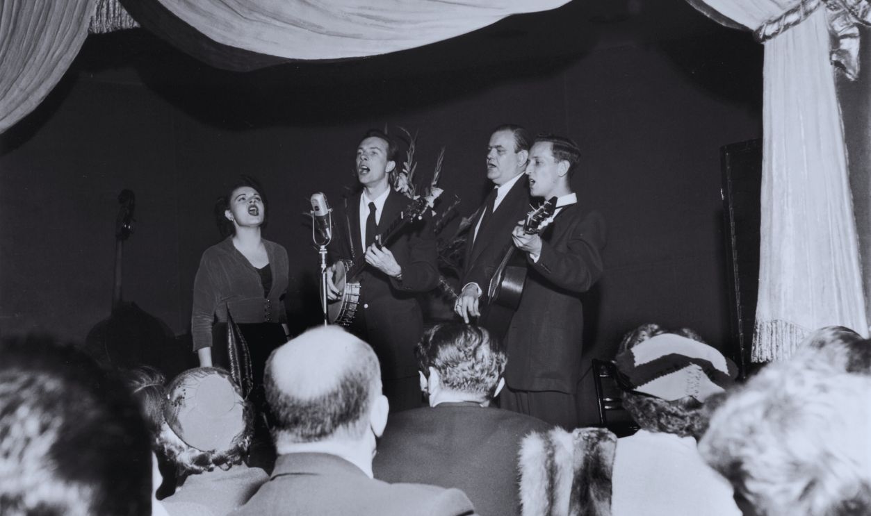 Gettyimages - 3205950, Pete Seeger circa 1948: American folk singer and banjo player Pete Seeger (C) performs on stage with his group, the Weavers, comprised of Lee Hays, Ronnie Gilbert, and Fred Hellerman, at the Blue Angel nightclub. Seeger plays the banjo while singing at the microphone.