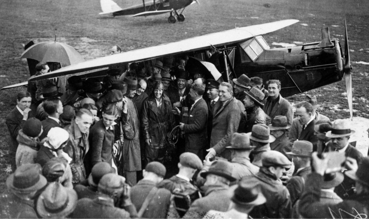 American aviator Amelia Earhart (1898 - 1937) (centre) is surrounded by a crowd of wellwishers and pressmen on arrival at Hanworth airfield after crossing the Atlantic. She is being congratulated on her flight in a Lockeed Vega by Andrew Mellon, US ambassador to Britain