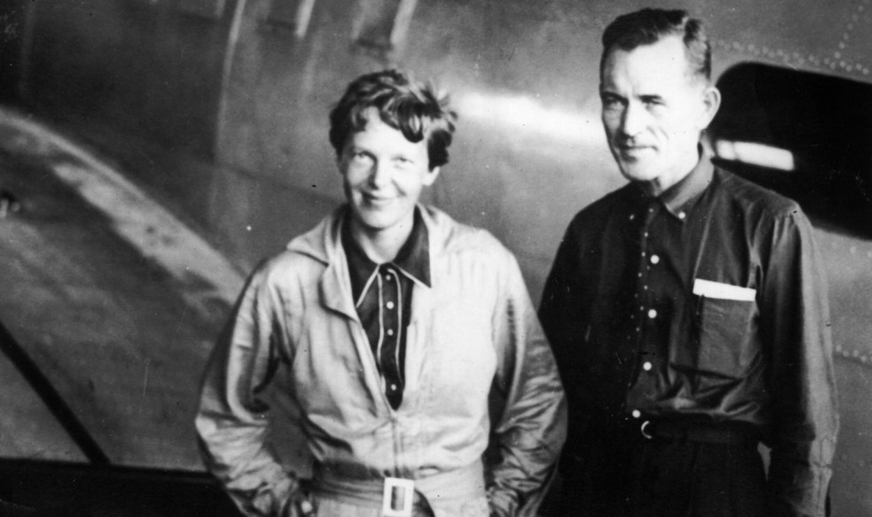 American aviatrix Amelia Earhart (1897 - 1937) with her navigator, Captain Fred Noonan, in the hangar at Parnamerim airfield, Natal, Brazil, 11th June 1937. Together they are attempting a circumnavigation of the globe. 
